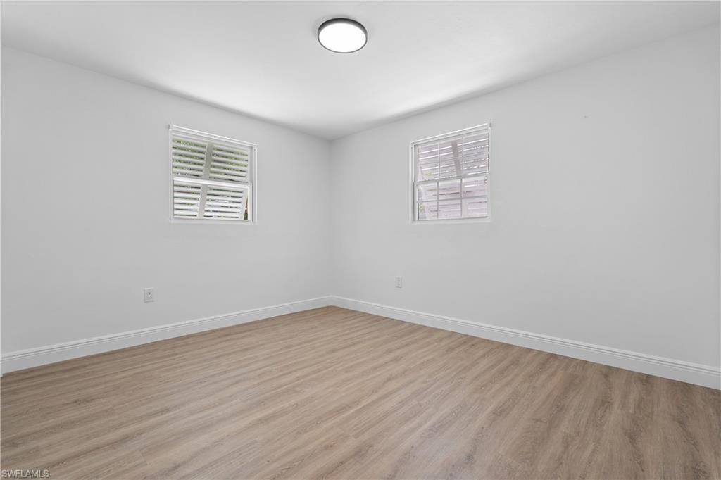 66 River Court Naples, FL 34110 - Photo 22 of 29 wooden floor in an empty room with a window