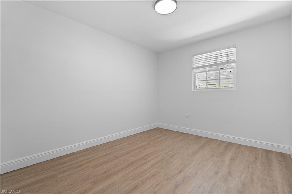 66 River Court Naples, FL 34110 - Photo 23 of 29 wooden floor in an empty room with a window