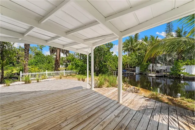a swimming pool with potted plants and large trees