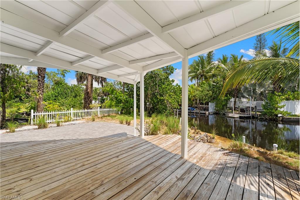 66 River Court Naples, FL 34110 - Photo 3 of 29 a swimming pool with potted plants and large trees