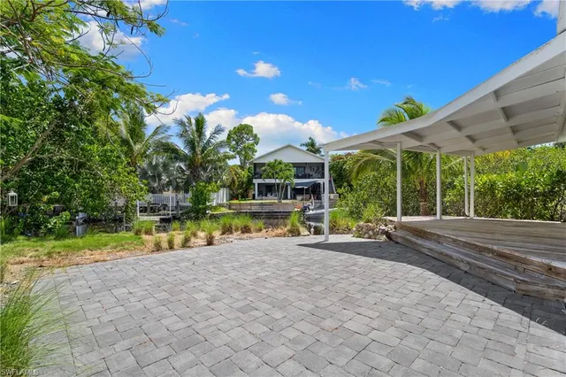 a view of a swimming pool with a patio and a yard