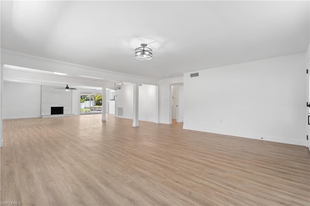 66 River Court Naples, FL 34110 - Photo 6 of 29 wooden floor in an empty room with a window