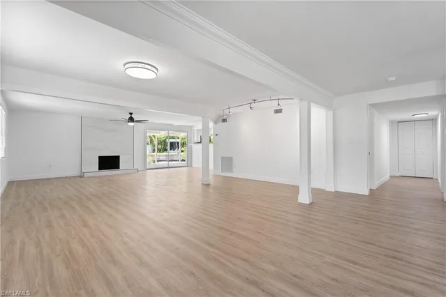 a view of empty room with a fireplace and wooden floor