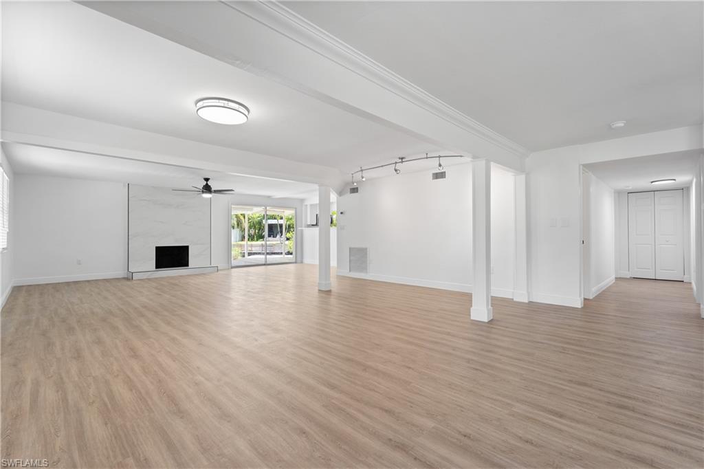 66 River Court Naples, FL 34110 - Photo 7 of 29 a view of empty room with a fireplace and wooden floor