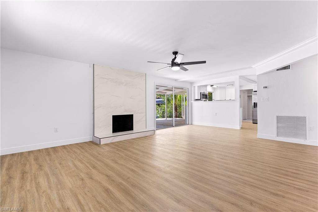 66 River Court Naples, FL 34110 - Photo 9 of 29 a view of an empty room with a window and wooden floor