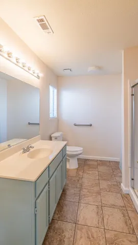 a bathroom with a granite countertop sink a toilet and mirror