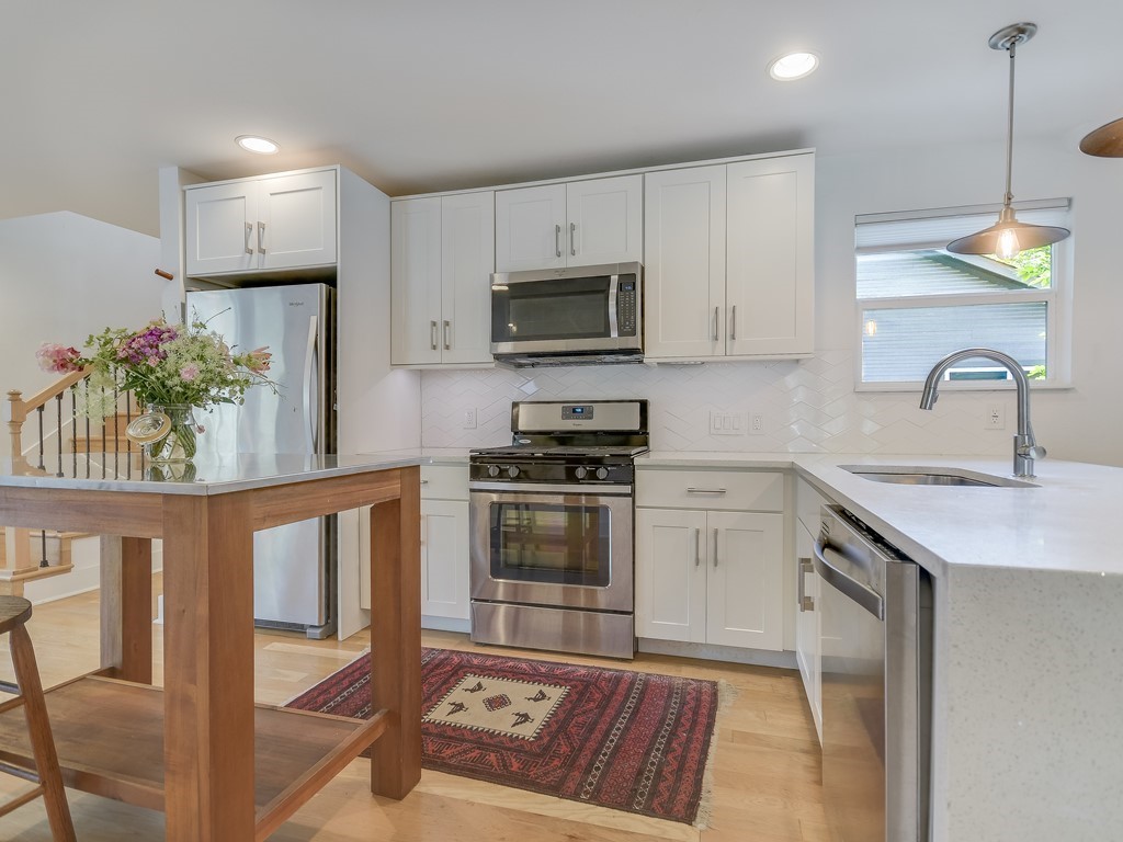 1313 Garden Street Austin, TX 78702 - Photo 8 of 23 a kitchen with granite countertop a stove a sink and a microwave