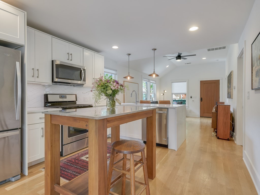1313 Garden Street Austin, TX 78702 - Photo 9 of 23 a kitchen with stainless steel appliances kitchen island granite countertop a refrigerator and a stove top oven