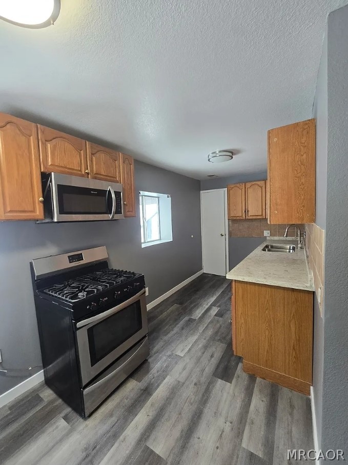 a kitchen with granite countertop a stove and a sink