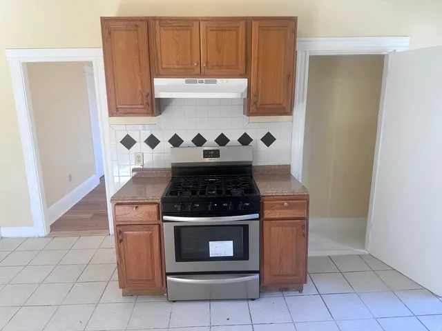 a stove top oven sitting inside of a kitchen