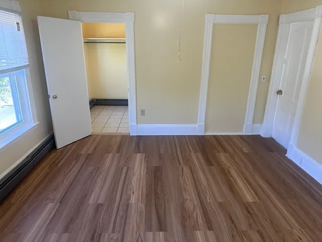 a view of a room with wooden floor and a window