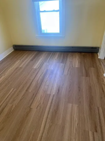 a view of a room with wooden floor and windows