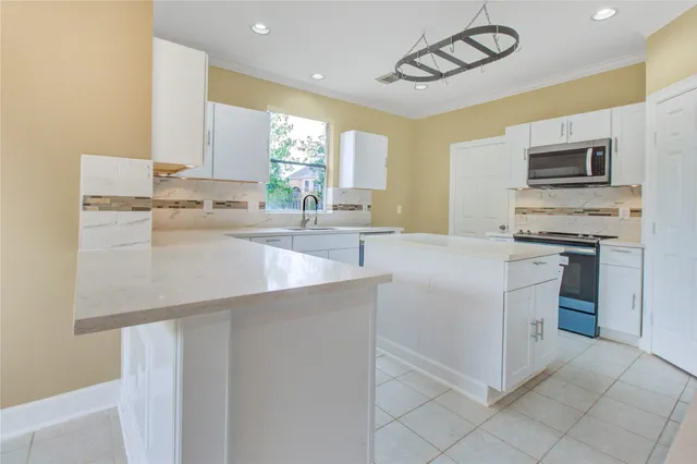a kitchen with stainless steel appliances a sink a stove a microwave and cabinets