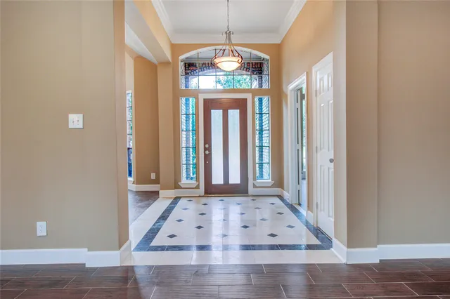 a view of a hallway with windows and chandelier