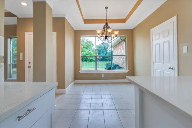 a view of a livingroom with a chandelier wooden floor and chandelier