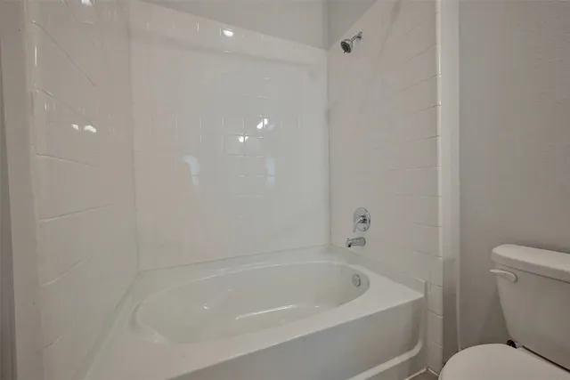 a white bath tub sitting next to a toilet