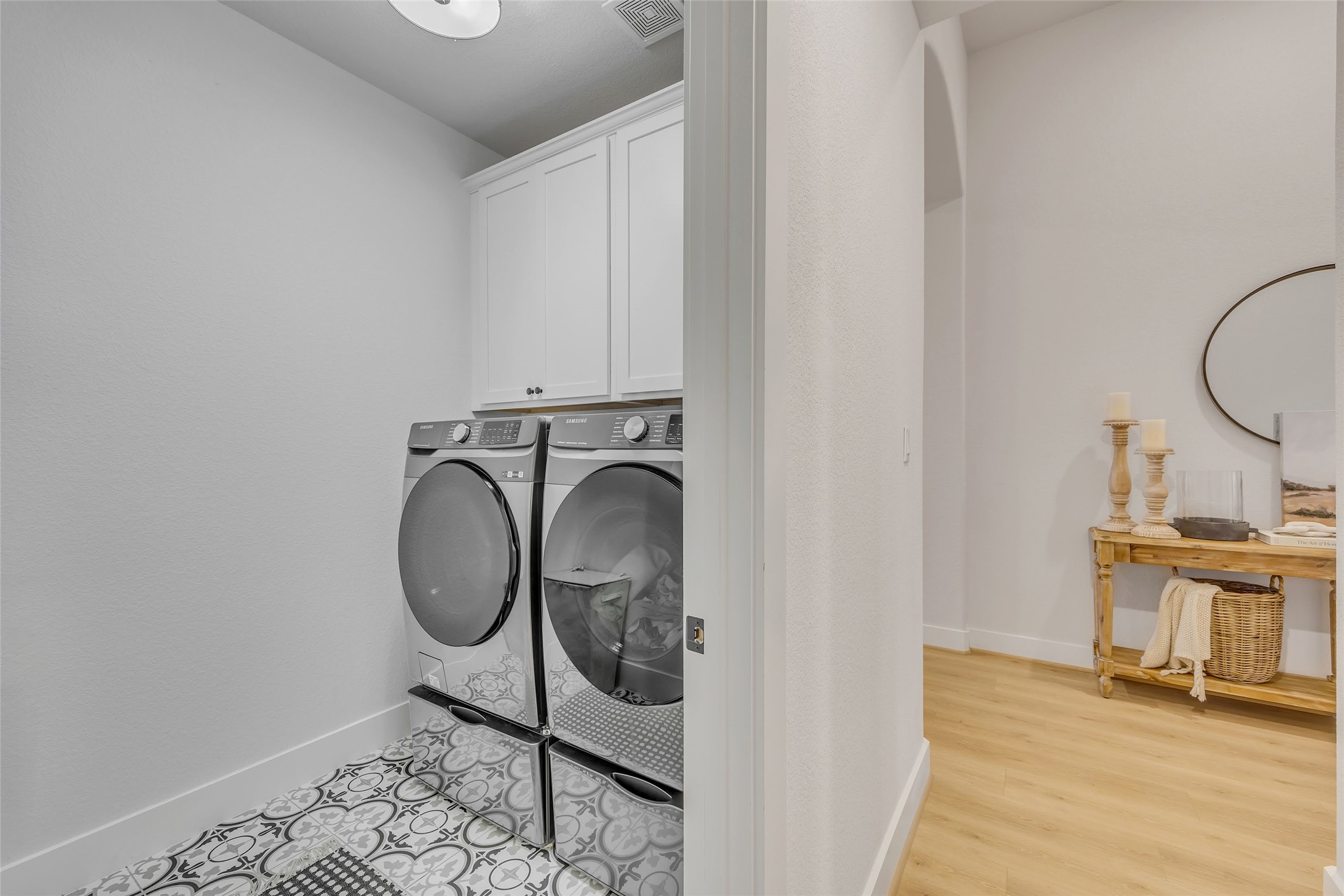 1901 Sir Nathaniel Lane Leander, TX 78641 - Photo 36 of 40 Laundry area featuring cabinet space, separate washer and dryer, light wood finished floors, and arched walkways