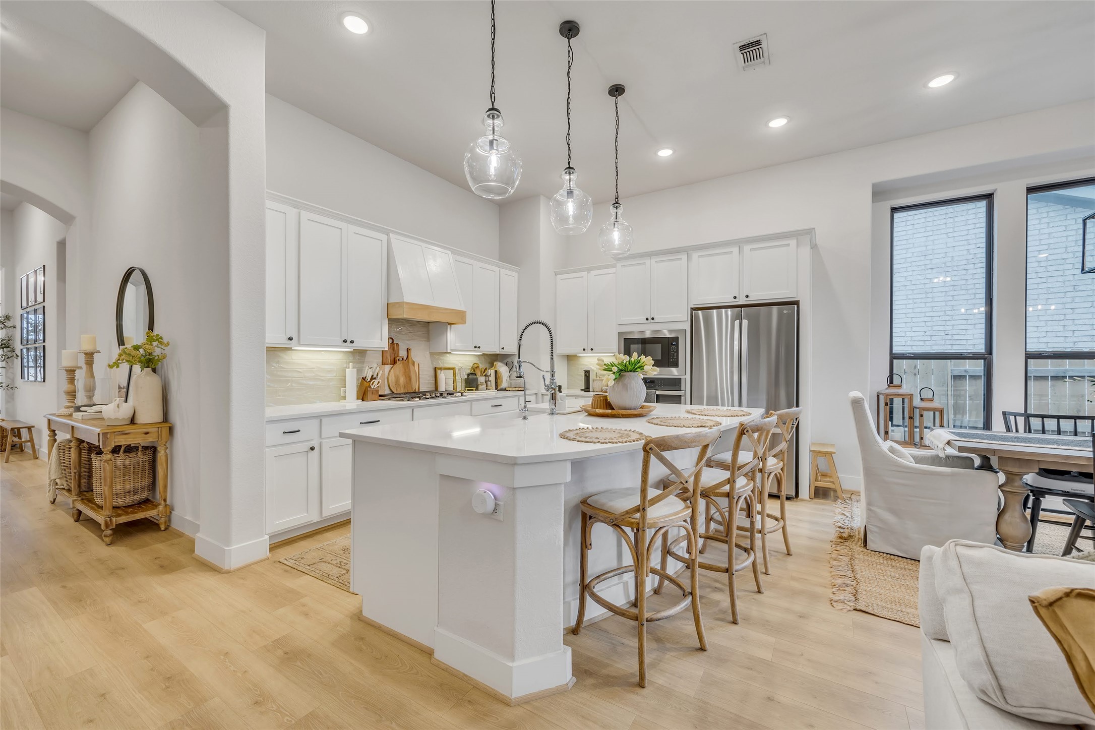 1901 Sir Nathaniel Lane Leander, TX 78641 - Photo 5 of 40 Kitchen with white cabinetry, a breakfast bar area, arched walkways, and an island with sink