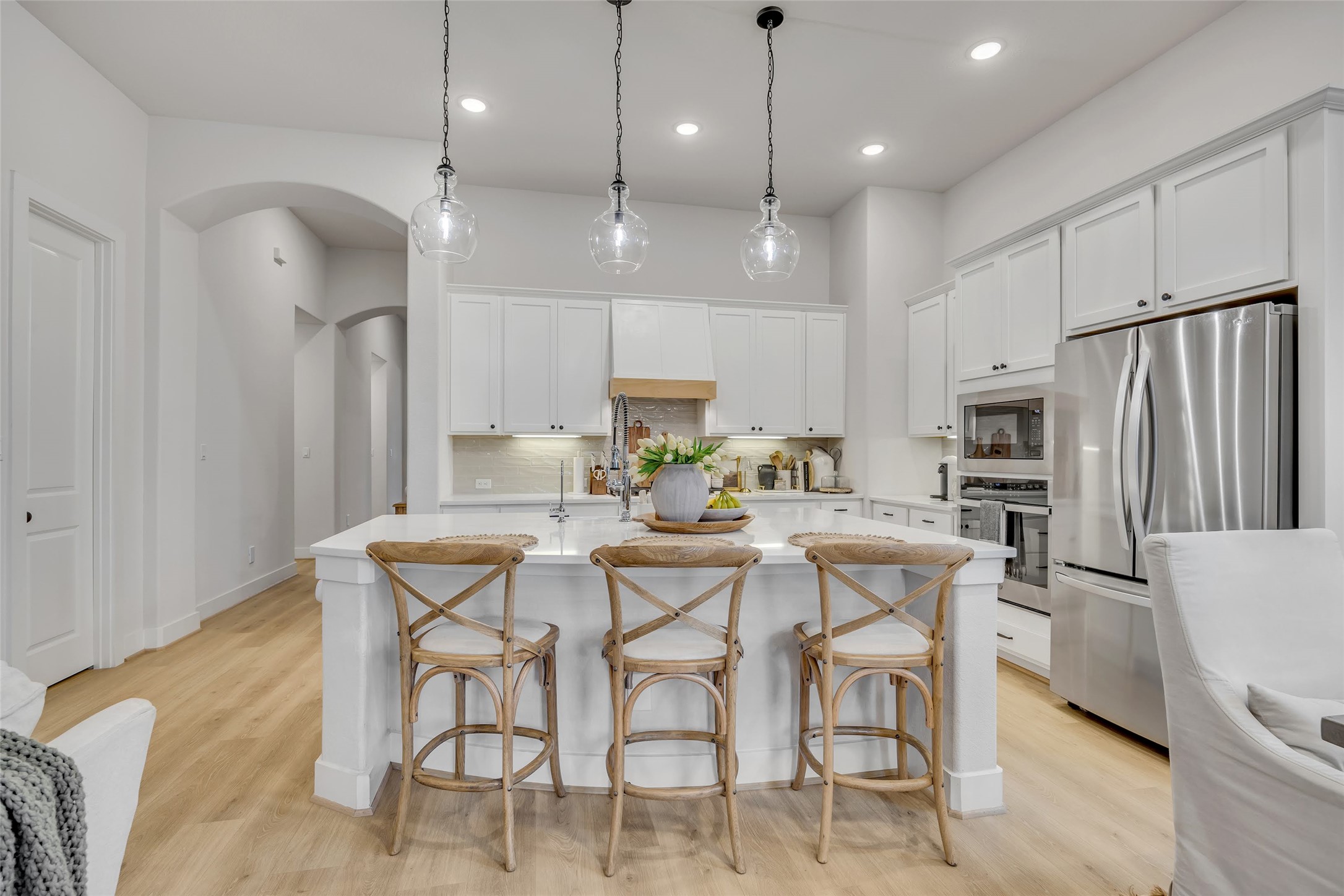 1901 Sir Nathaniel Lane Leander, TX 78641 - Photo 10 of 40 Kitchen featuring stainless steel appliances, white cabinets, decorative light fixtures, and a kitchen breakfast bar