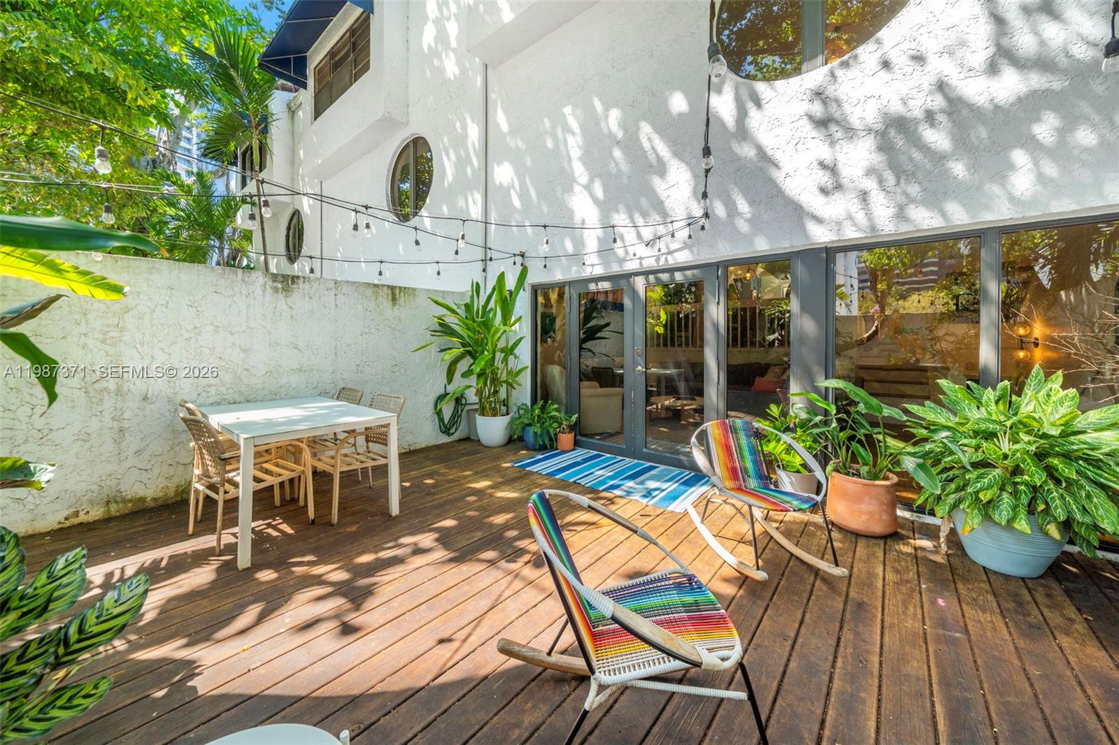 3237 Mary Street, Unit 6 Miami, FL 33133 - Photo 23 of 54 a view of a patio with table and chairs potted plants with wooden floor
