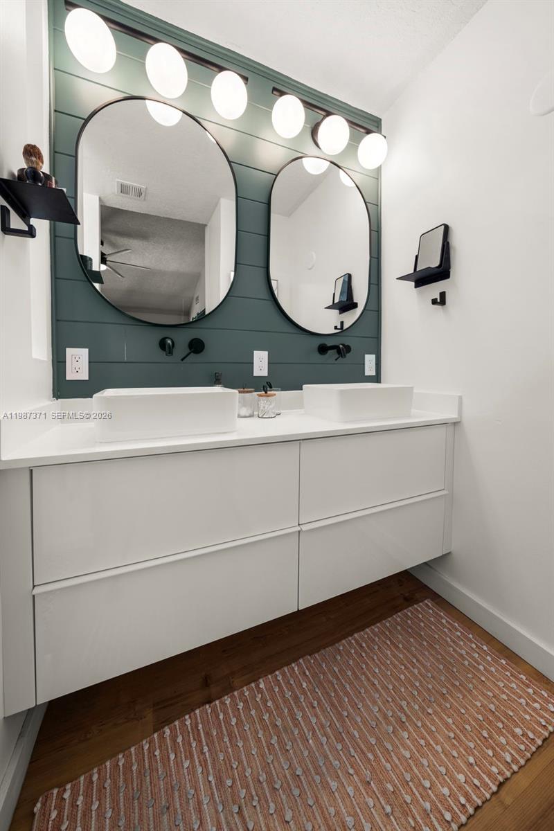 3237 Mary Street, Unit 6 Miami, FL 33133 - Photo 37 of 54 a bathroom with a double vanity sink and a mirror