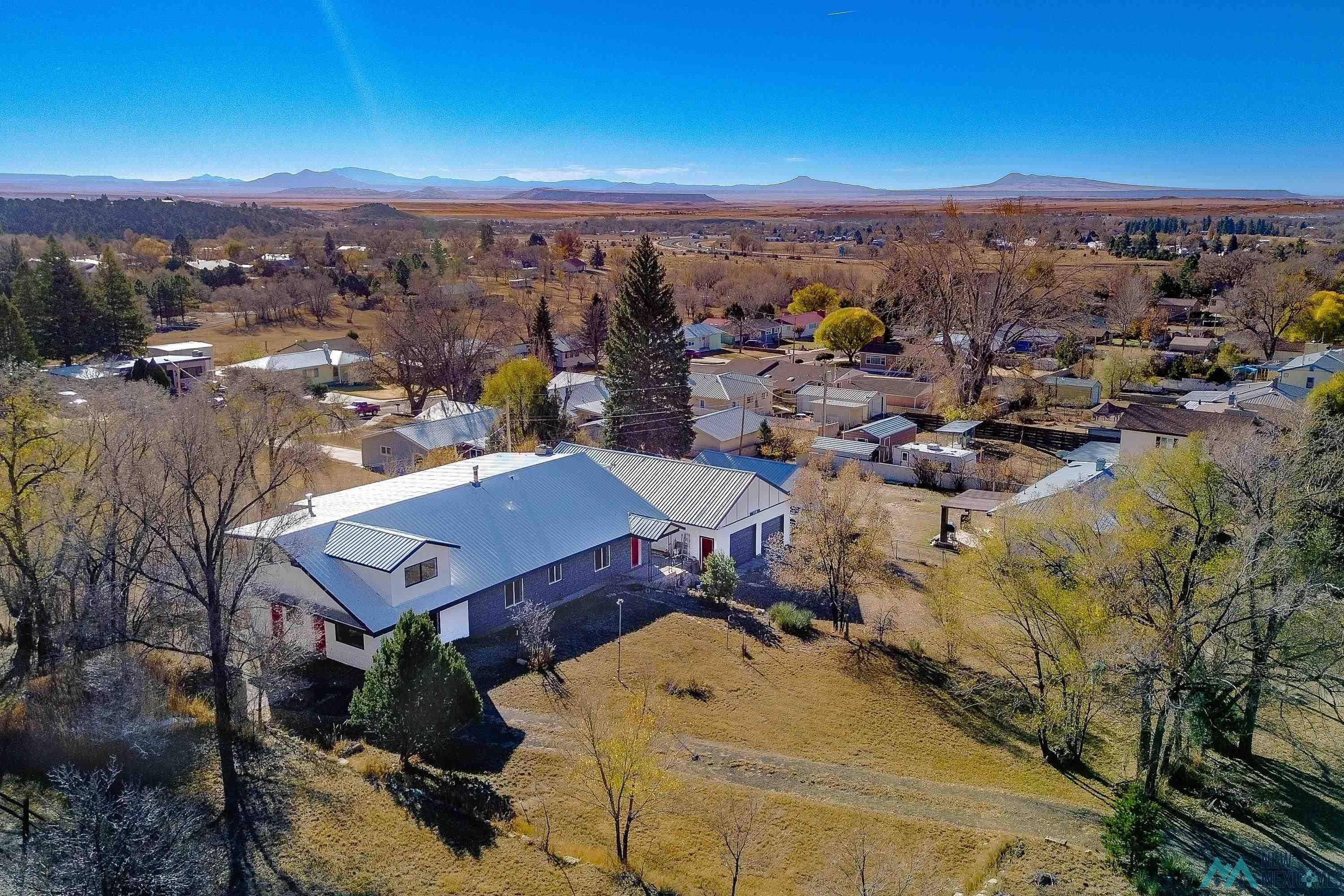 1131 Lincoln Avenue Raton, NM 87740 - Photo 36 of 41 Aerial view of property and surrounding area with a mountain backdrop and nearby suburban area