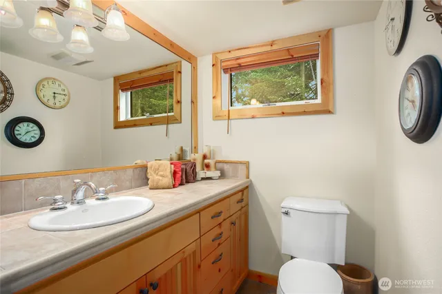 a bathroom with a toilet a sink and a mirror
