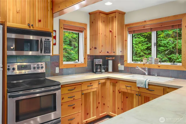 a kitchen with stainless steel appliances granite countertop a sink and a stove