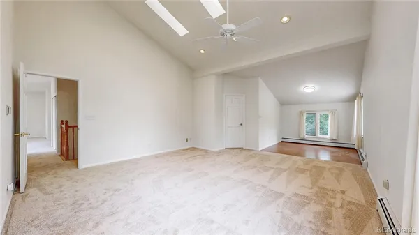 an empty room with closet and a ceiling fan