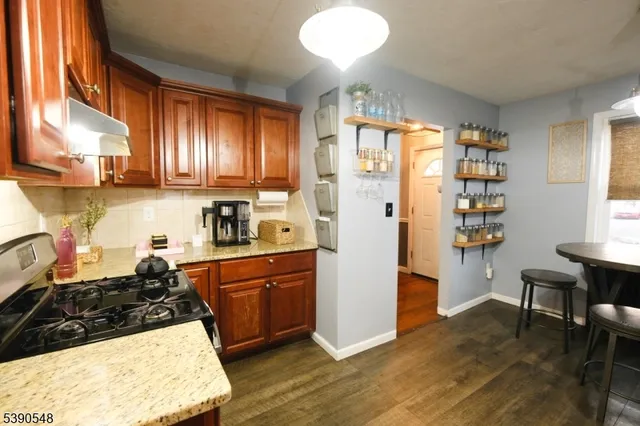 a kitchen with stainless steel appliances a dining table chairs refrigerator and sink