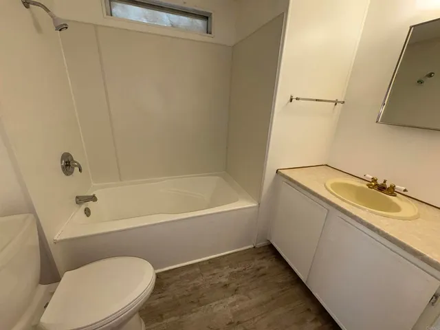 a bathroom with a granite countertop sink mirror vanity and toilet