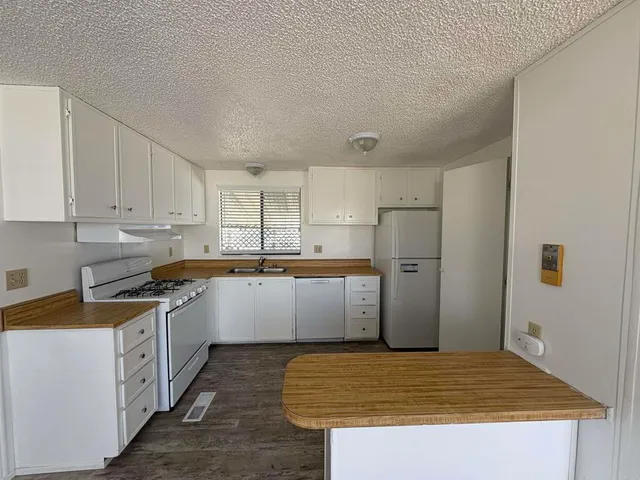 a view of a big room with wooden floor and windows