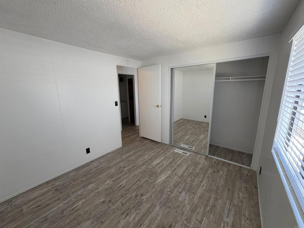 41 Hummingbird Lane Oceanside, CA 92057 - Photo 9 of 13 a view of an empty room with wooden floor and a window