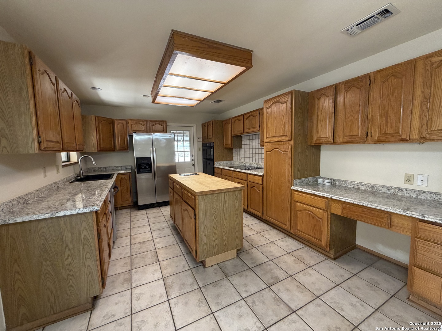 1236 East Live Oak Road Schertz, TX 78154 - Photo 4 of 20 a kitchen with granite countertop a sink a counter top space cabinets and stainless steel appliances