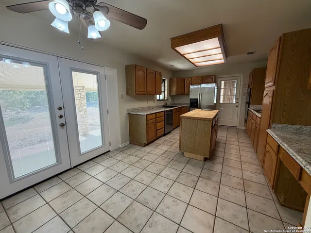 a kitchen with stainless steel appliances granite countertop a refrigerator and a stove top oven