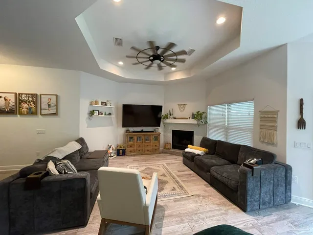 a living room with furniture a fireplace and a flat screen tv