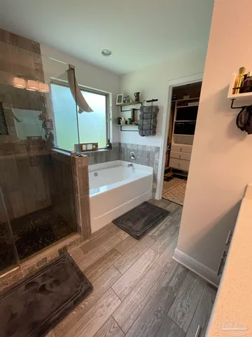 a living room with stainless steel appliances furniture a rug and a view of bathroom