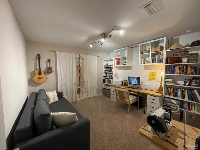 a living room with furniture and a book shelf
