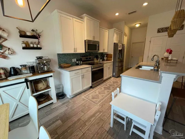 a kitchen with wooden floors and refrigerator