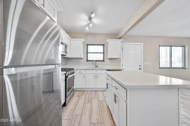 a kitchen with white cabinets and white appliances