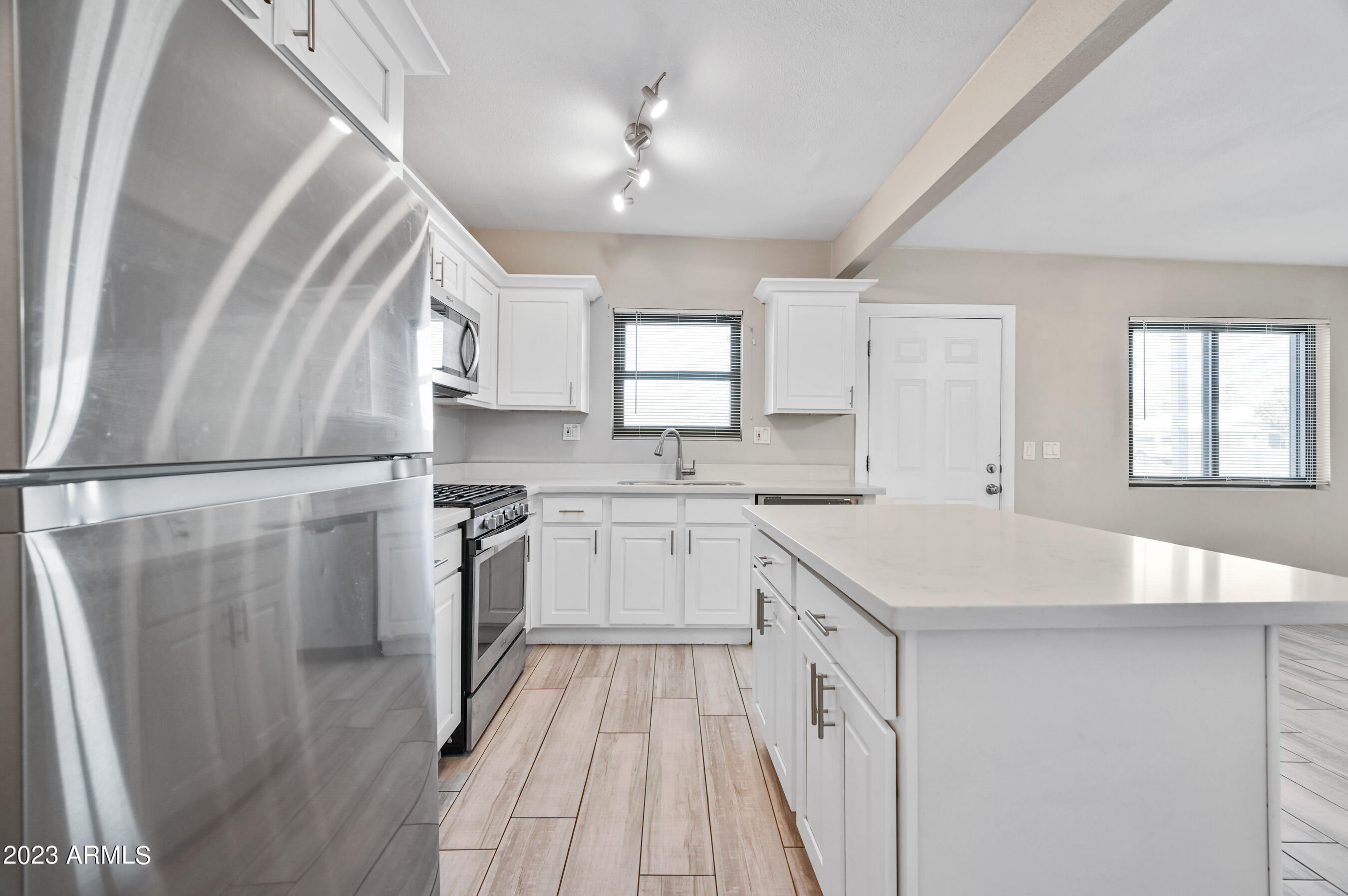 1145 East Henry Street Tempe, AZ 85288 - Photo 5 of 15 a kitchen with white cabinets and white appliances