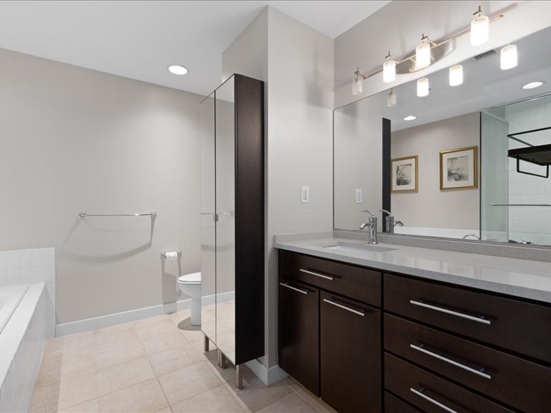 1245 Adams Street, Unit B210 Boston, MA 02124 - Photo 19 of 39 a spacious bathroom with a granite countertop sink a toilet and a mirror