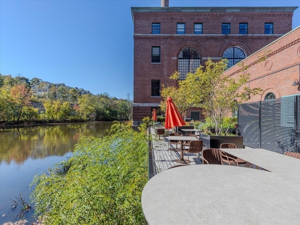 1245 Adams Street, Unit B210 Boston, MA 02124 - Photo 30 of 39 a view of a lake with a table and chairs