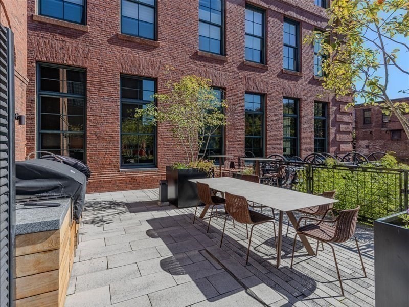 1245 Adams Street, Unit B210 Boston, MA 02124 - Photo 32 of 39 a view of a patio with table and chairs and potted plants