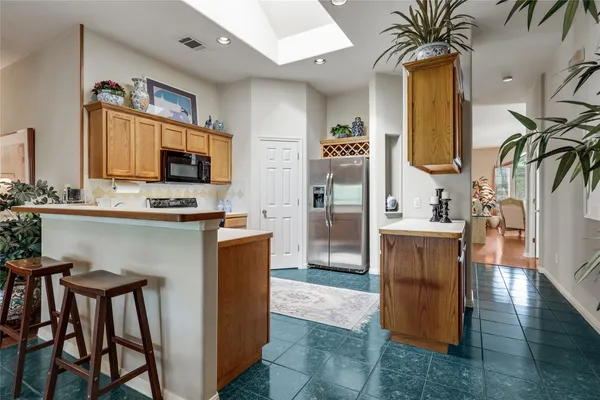 a kitchen with stainless steel appliances kitchen island granite countertop a table and chairs in it