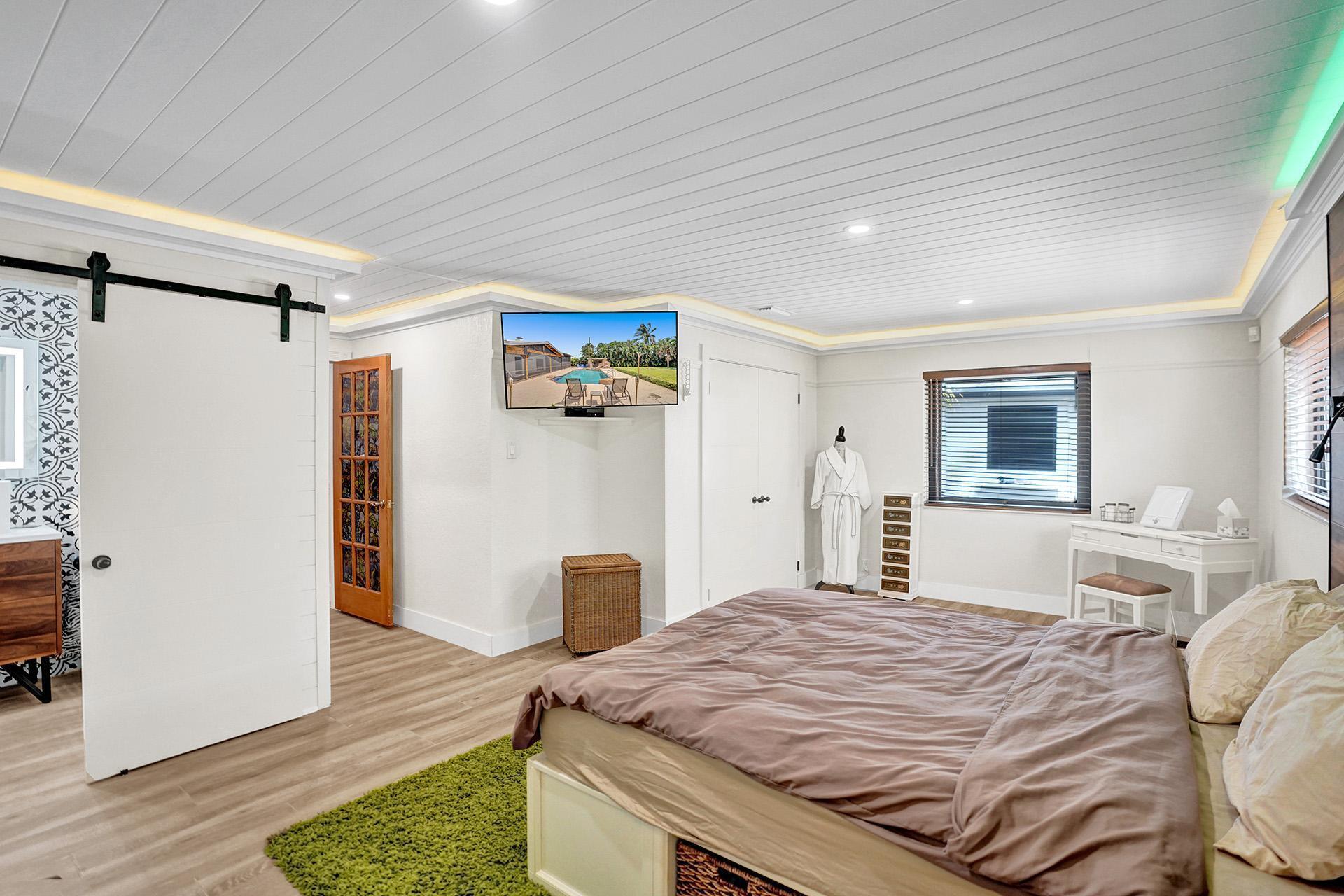 5612 Harding Street Hollywood, FL 33021 - Photo 30 of 59 a bedroom with a bed and a dresser with wooden floor