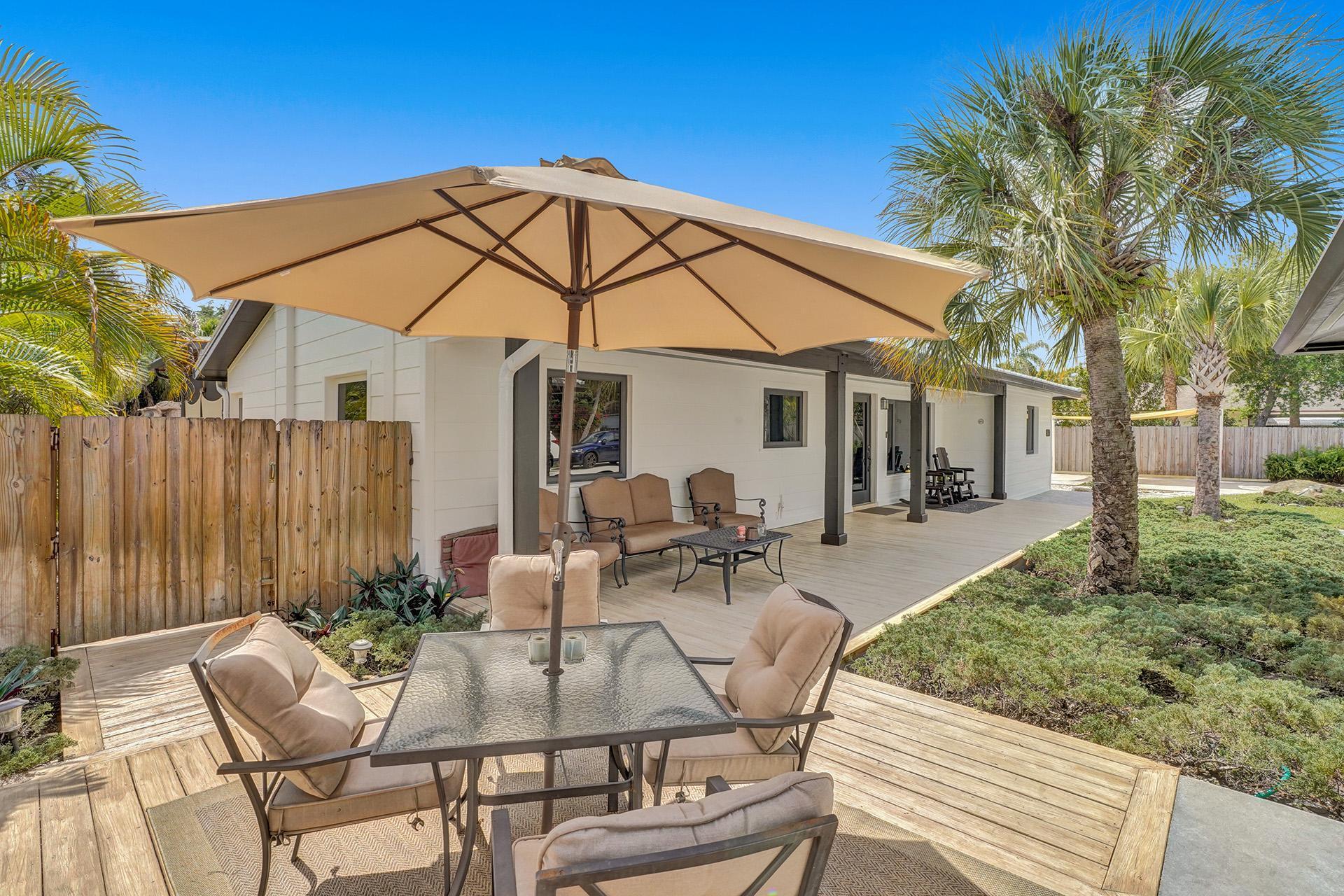 5612 Harding Street Hollywood, FL 33021 - Photo 51 of 59 a view of a patio with table and chairs under an umbrella