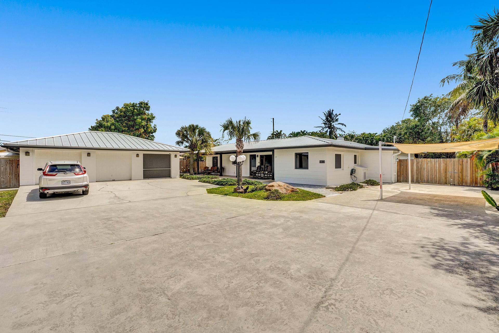 5612 Harding Street Hollywood, FL 33021 - Photo 53 of 59 a view of a white house with a large space and a car parked in front of it
