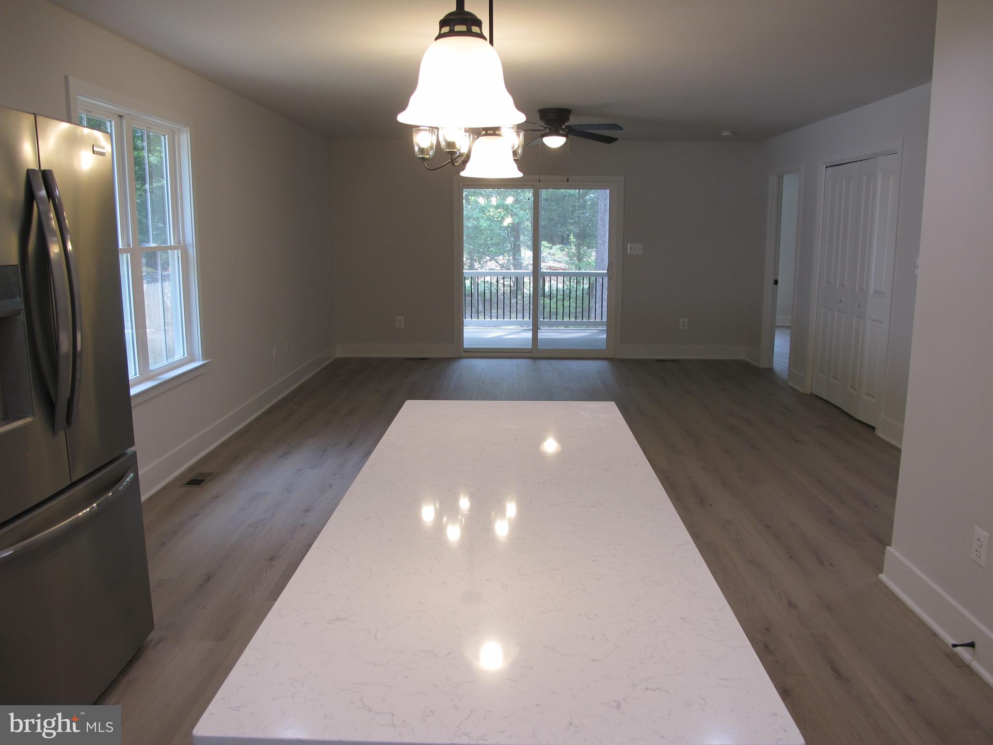145 9th Street Colonial Beach, VA 22443 - Photo 17 of 51 en empty room with windows and chandelier fan