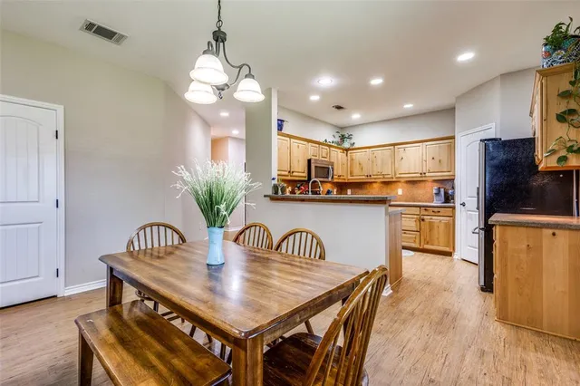 a kitchen with kitchen island a table and chairs in it